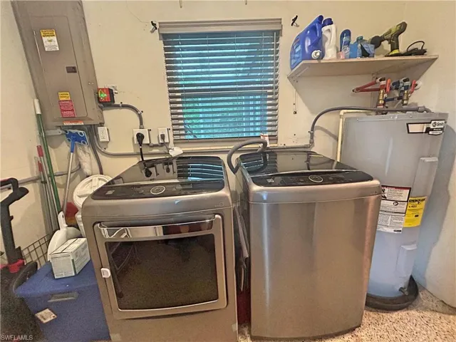 Laundry room featuring electric water heater, separate washer and dryer, and electric panel