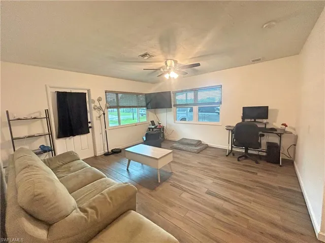 Living room with ceiling fan and wood look tile flooring