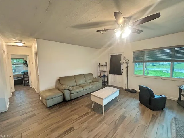 Living room with ceiling fan and wood look tile flooring