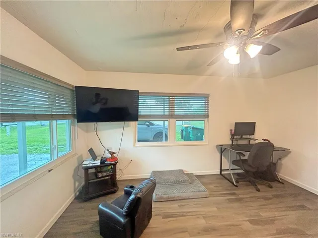 Living room with ceiling fan and wood look tile flooring