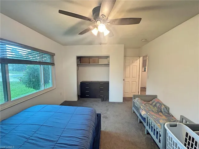 Bedroom with a closet, carpet floors, and ceiling fan