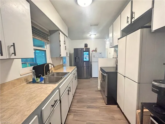 Kitchen featuring sink, wood look tile floors