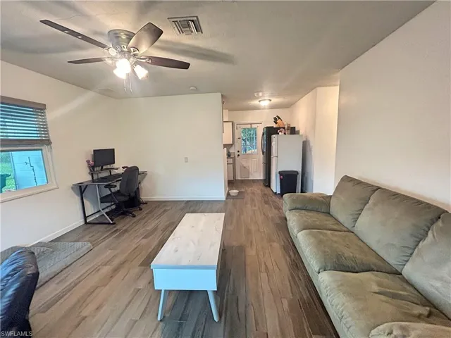 Living room with ceiling fan and wood look tile flooring