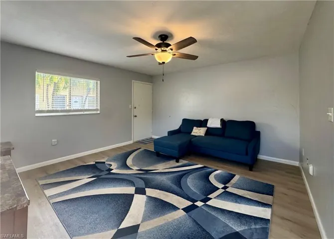 Living area featuring a ceiling fan and light wood-type flooring