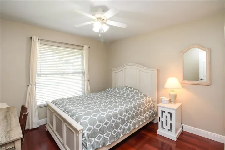 Bedroom with ceiling fan, baseboards, and dark wood finished floors