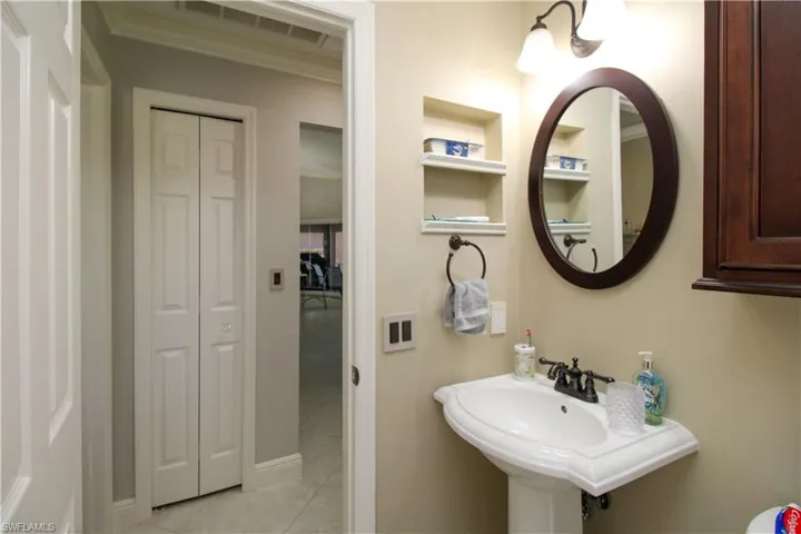Bathroom with built in features, a closet, a sink, and tile patterned flooring