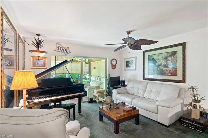 Living area featuring carpet flooring, a ceiling fan and Grand Piano