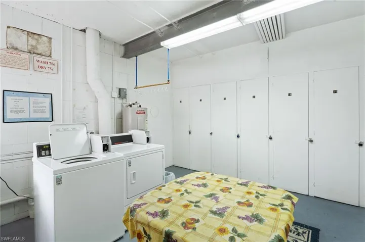 Shared laundry featuring washer and dryer, electric water heater, and extra storage closets.