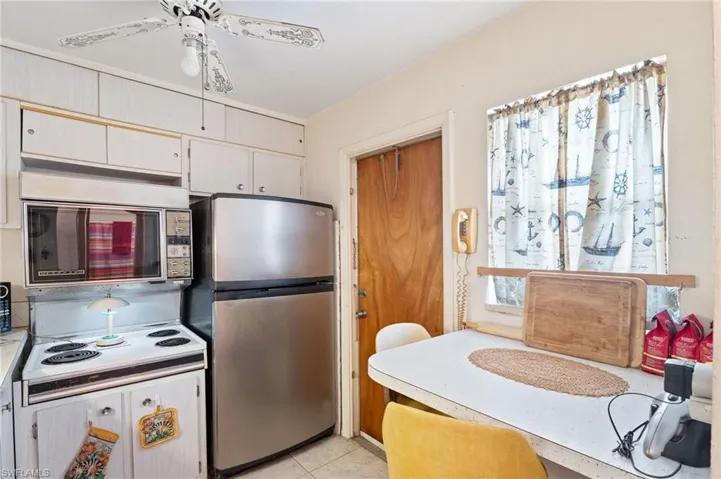 Kitchen with stainless steel refrigerator, light countertops, and light tile patterned floors