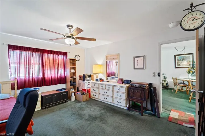 Office area featuring dark carpet and a ceiling fan