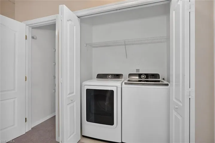Dedicated laundry area featuring bi-fold doors and overhead wire shelving