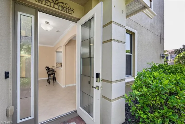 Entryway featuring a decorative glass paneled door, a sidelight with textured glass, and a smart lock system