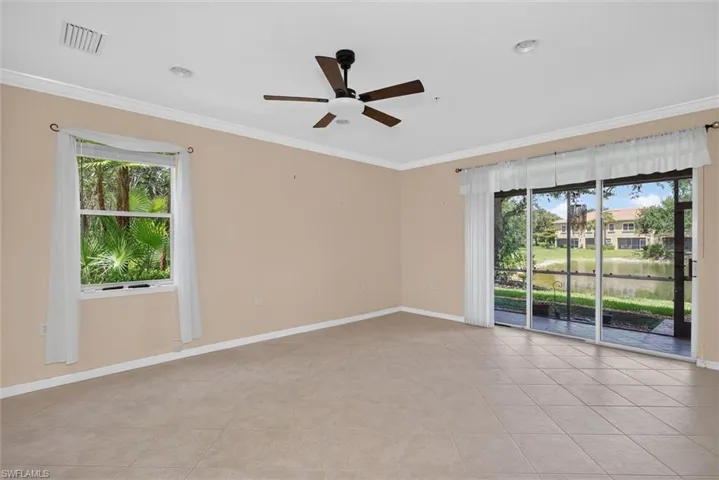 Spacious interior featuring neutral tone tile flooring and crown molding