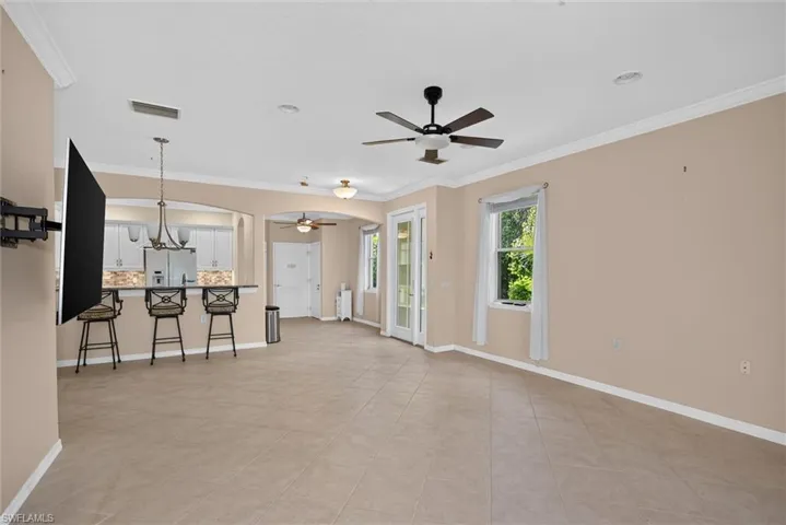 Spacious interior with tile flooring and crown molding