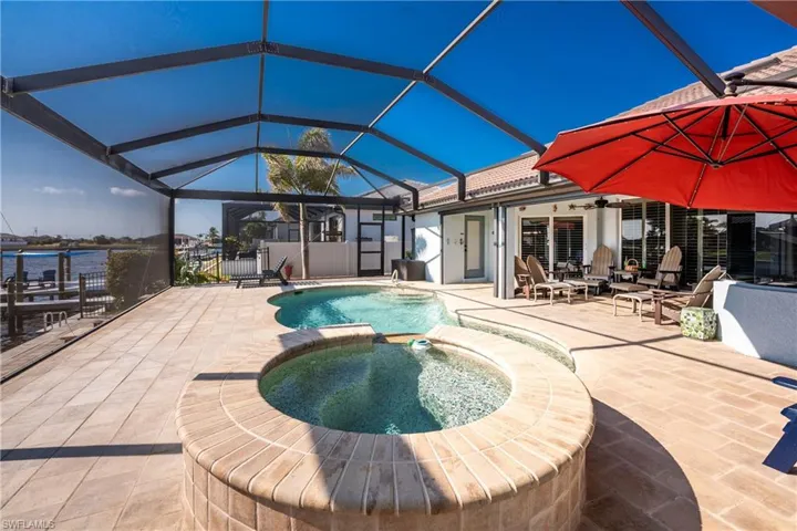 View of swimming pool featuring a lanai, a sunroom, a patio area, and a pool with connected hot tub