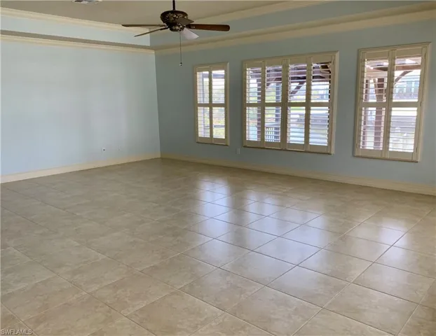 Spare room featuring crown molding and ceiling fan