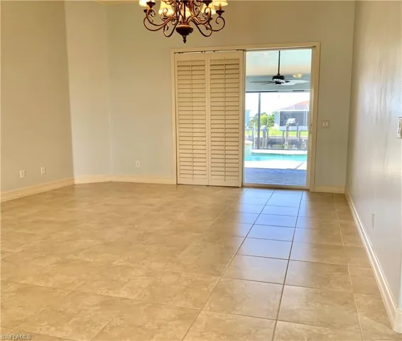Unfurnished room with a chandelier, a ceiling fan, and light tile patterned flooring