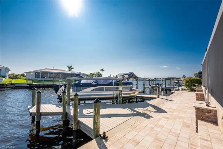 Dock area featuring boat lift and a water view