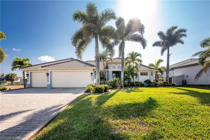 Mediterranean / spanish-style home with a front yard, decorative driveway, a garage, stucco siding, and a tile roof