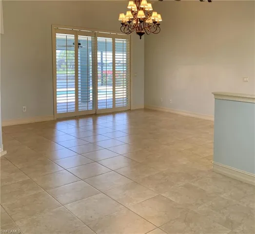 Empty room featuring a chandelier and light tile patterned floors