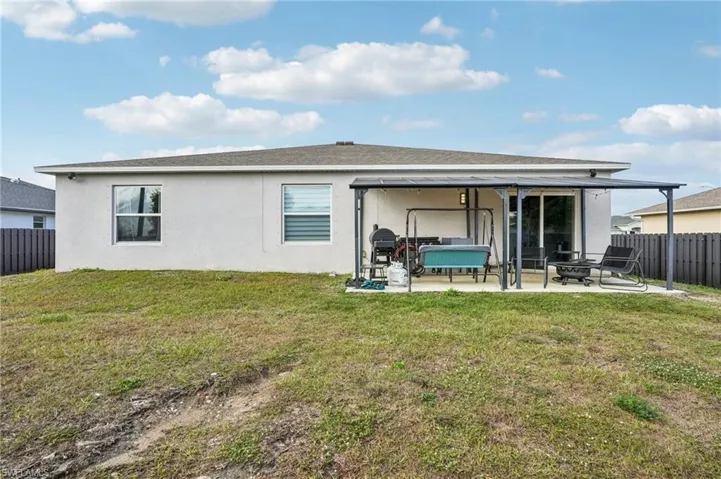 Back of property featuring a fenced backyard, a patio, stucco siding, and roof with shingles