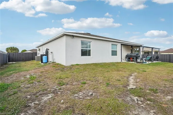 Back of house with a fenced backyard, a patio area, and stucco siding