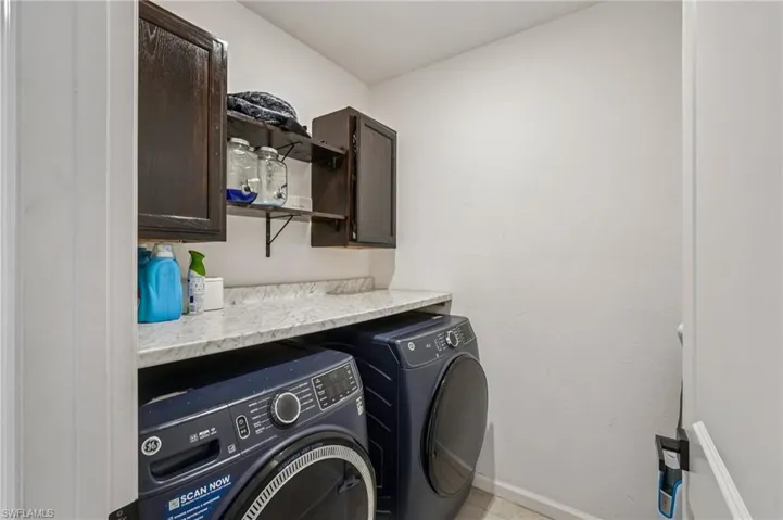 Washroom featuring cabinet space and washing machine and dryer