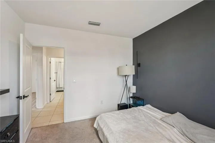 Bedroom with light colored carpet and baseboards