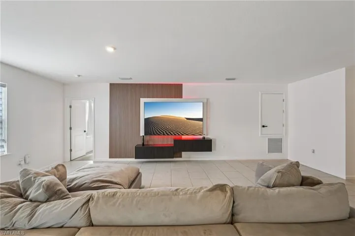 Tiled living area featuring recessed lighting