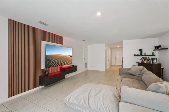 Living area with light tile patterned flooring and recessed lighting