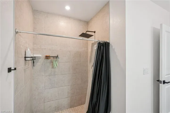 Bathroom with a shower stall and recessed lighting