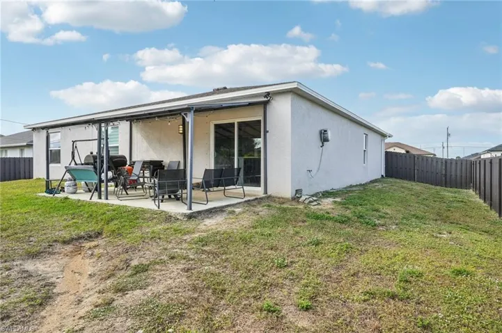 Back of property with a fenced backyard, stucco siding, and a patio