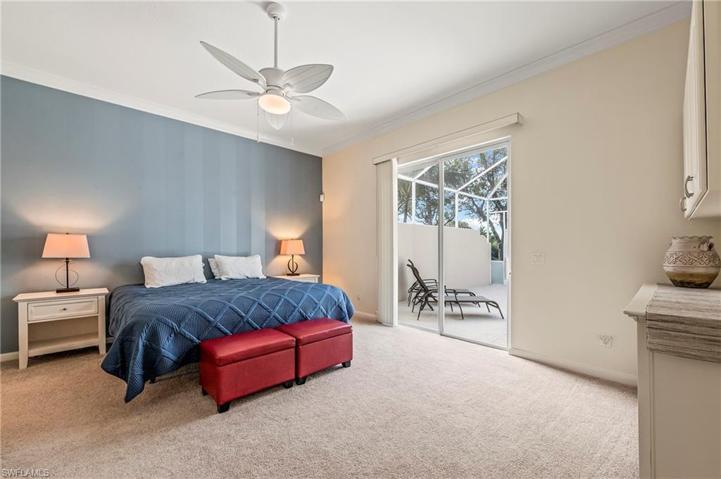 28353 Moray Dr Bonita Springs FL 34135 - Owner's bedroom has an impact glass slider, king sized bed, and overlooks the pool and water feature.