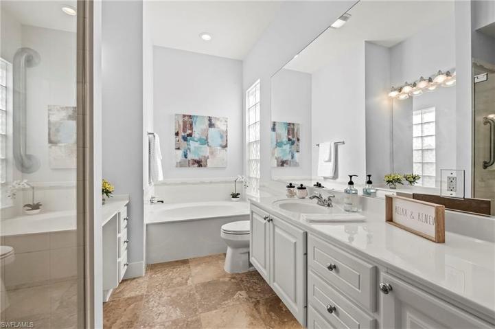 28353 Moray Dr Bonita Springs FL 34135 - Owner's bath has a vanity area, separate commodes, glass shower doors, and a soaking tub