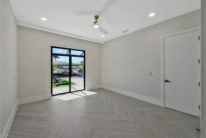 Empty room featuring recessed lighting, a ceiling fan, and a water view