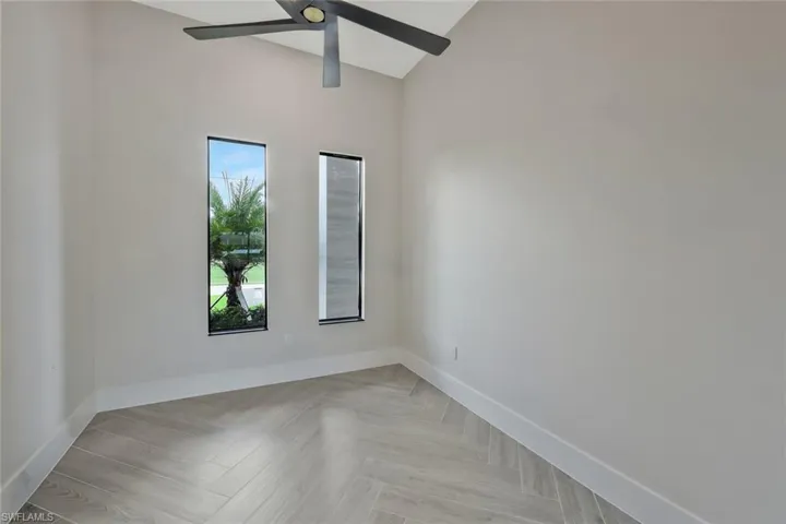 Empty room featuring baseboards and a ceiling fan