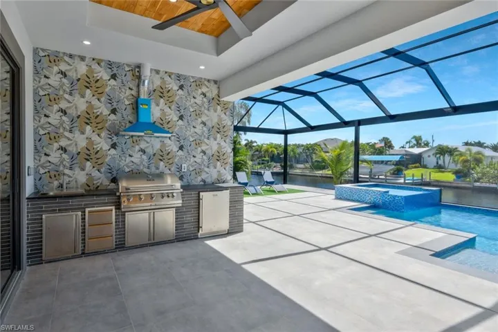 View of patio / terrace with a water view, a lanai, a sunroom, a pool with connected hot tub, and ceiling fan