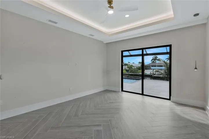 Spare room with a raised ceiling, ceiling fan, and a sunroom