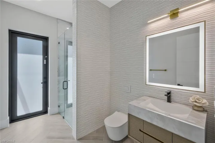 Full bathroom featuring vanity, a shower stall, and tile walls