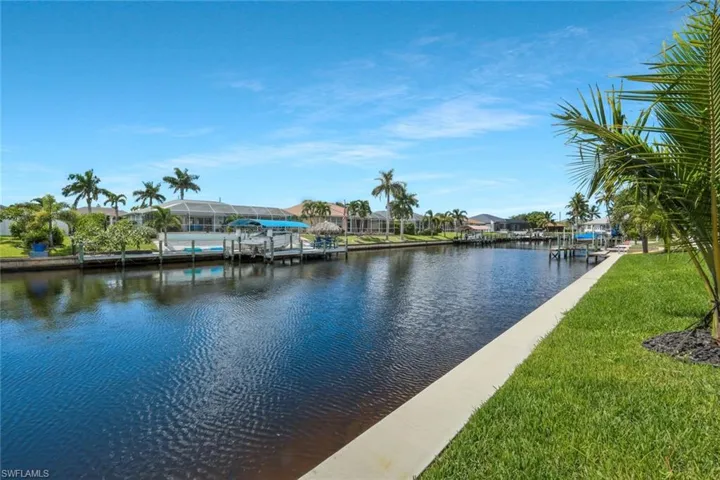 Water view featuring nearby suburban area and a dock