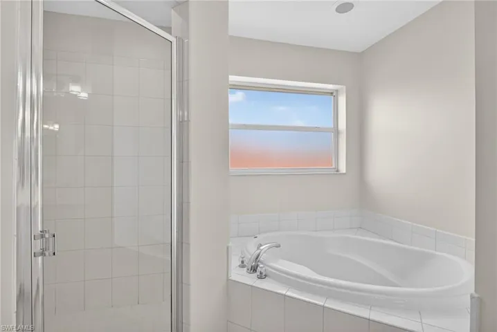 Full bath with a shower and a garden tub