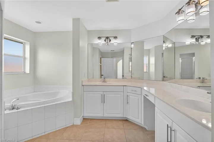 Bathroom with double vanity, a bath, and a separate enclosed shower
