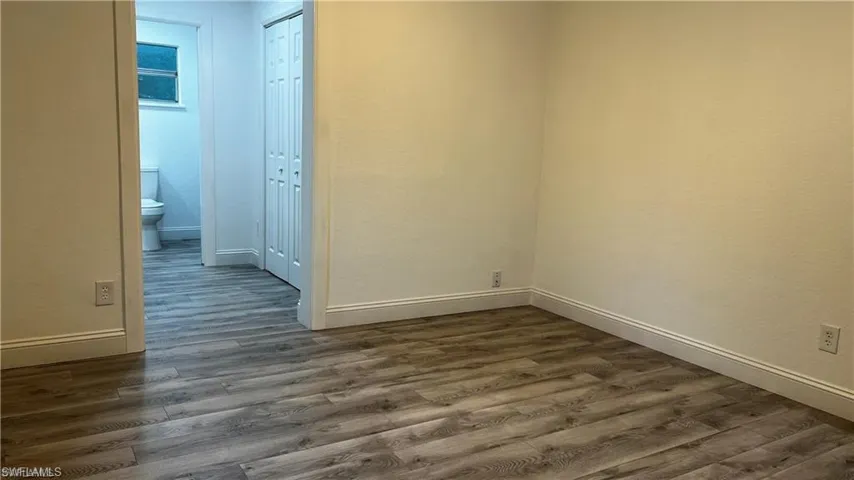 Unfurnished room with baseboards and dark wood finished floors
