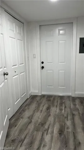 Doorway to outside featuring baseboards and dark wood finished floors