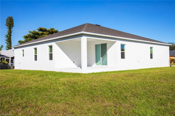 Back of property featuring a yard, stucco siding, and a patio