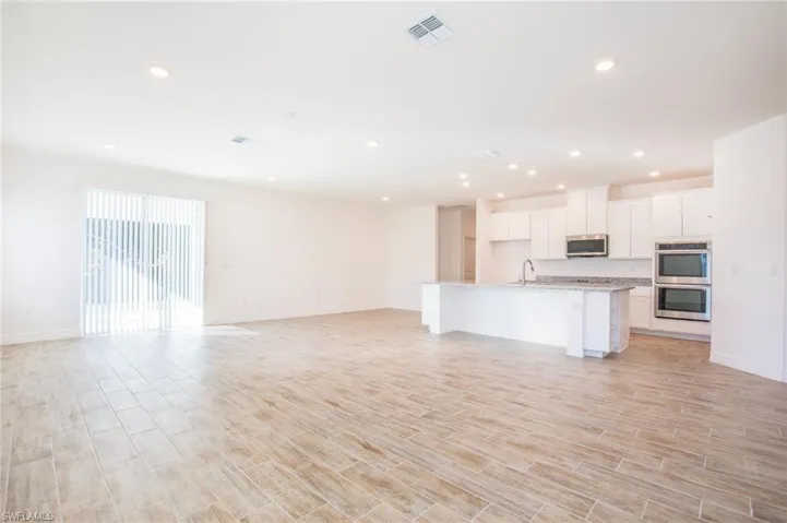 Unfurnished living room with wood tiled floors and recessed lighting