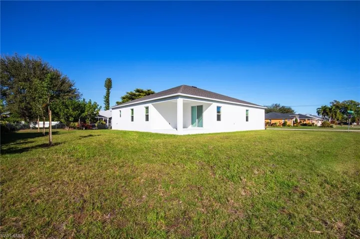 Back of house featuring a yard, stucco siding, and a patio area