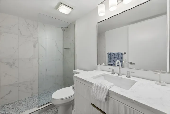 Full bathroom with vanity and a marble finish shower