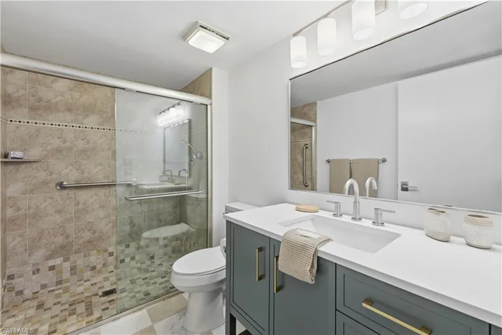 Full bathroom with vanity and a stall shower