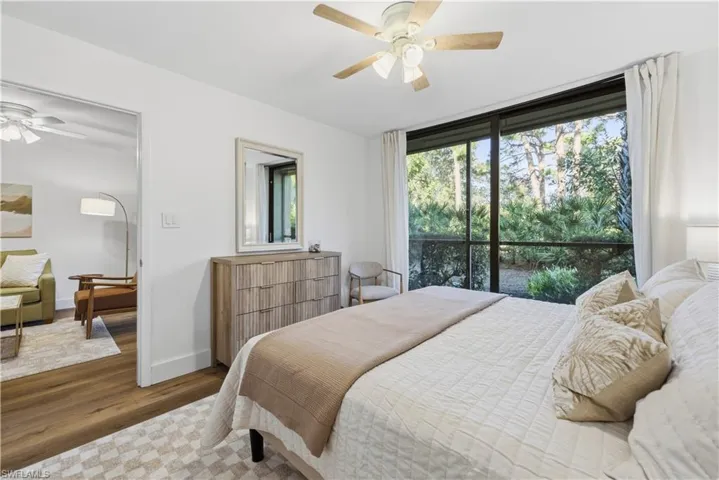Bedroom with a ceiling fan, wood finished floors, and access to outside
